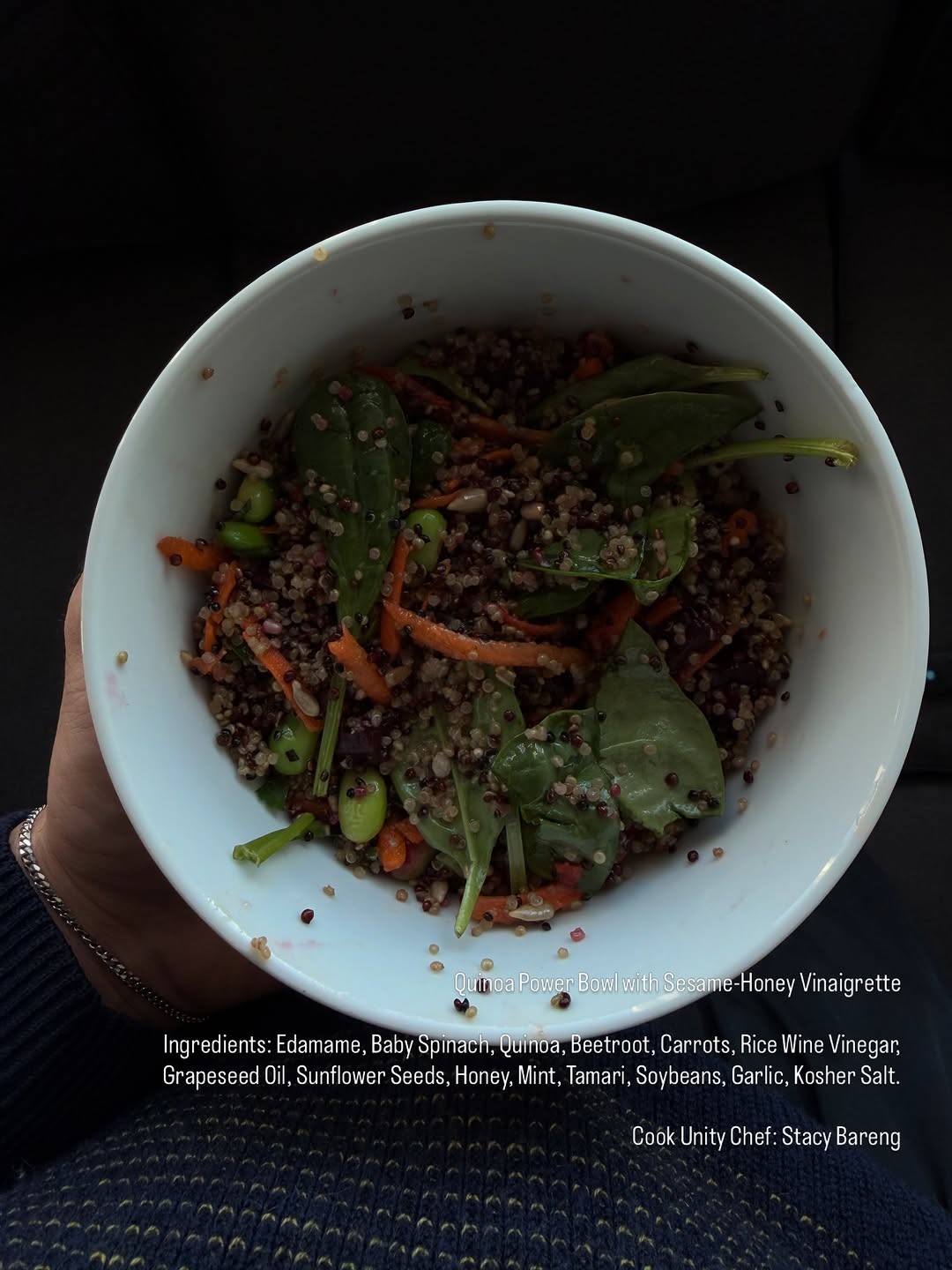 A vibrant quinoa power bowl featuring edamame, baby spinach, beets, carrots, and a sesame-honey vinaigrette.