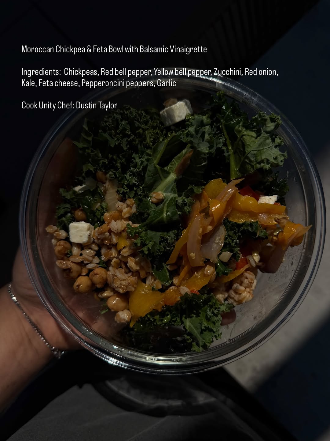 A close-up view of a Moroccan chickpea and feta bowl featuring various colorful vegetables and grains, topped with feta cheese.