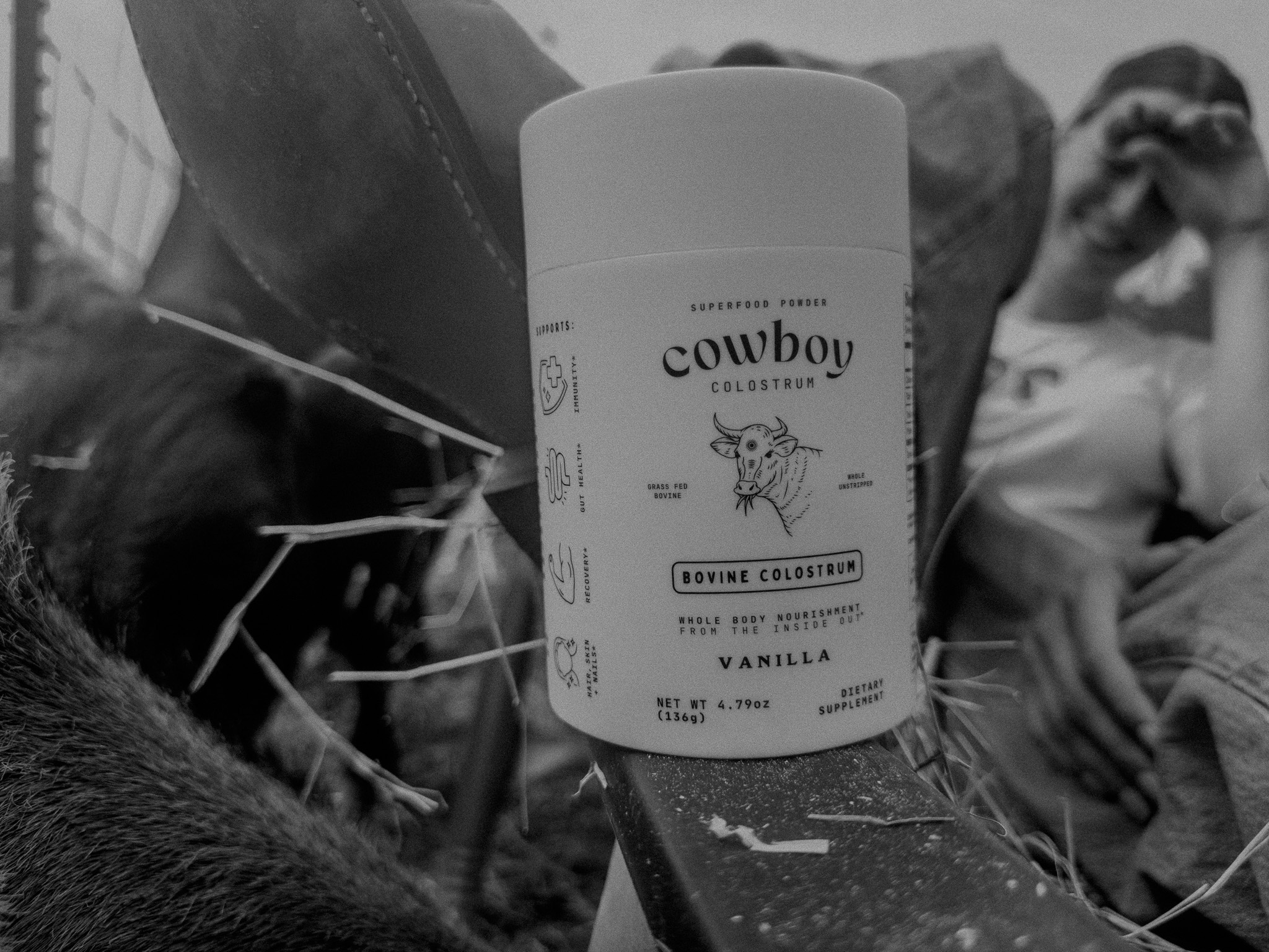 A close-up of a cowboy-themed deodorant stick with a vanilla scent, set against a blurred background of a person relaxing outdoors.