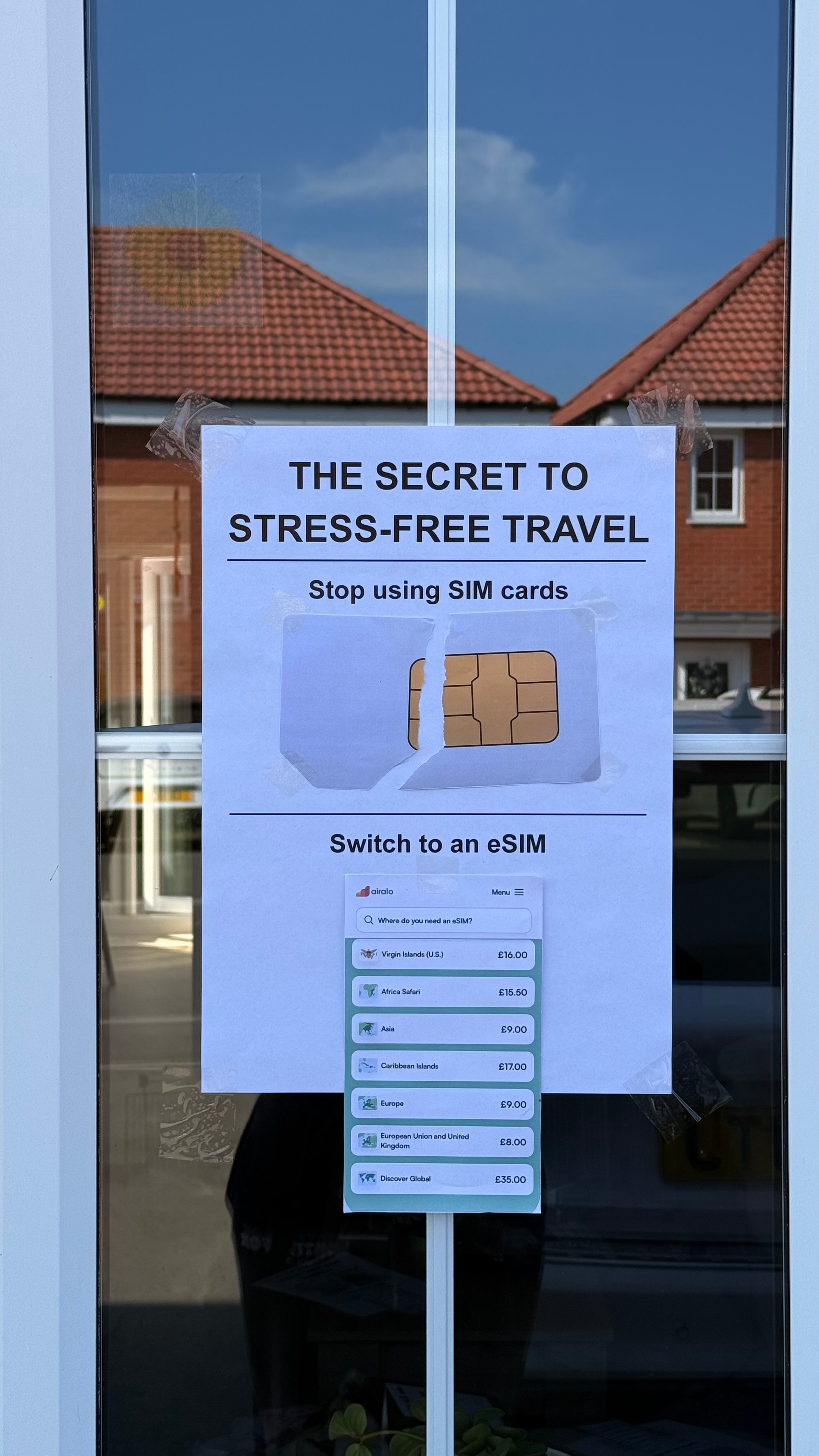 A poster on a glass door promoting the benefits of using an eSIM instead of traditional SIM cards for travel.