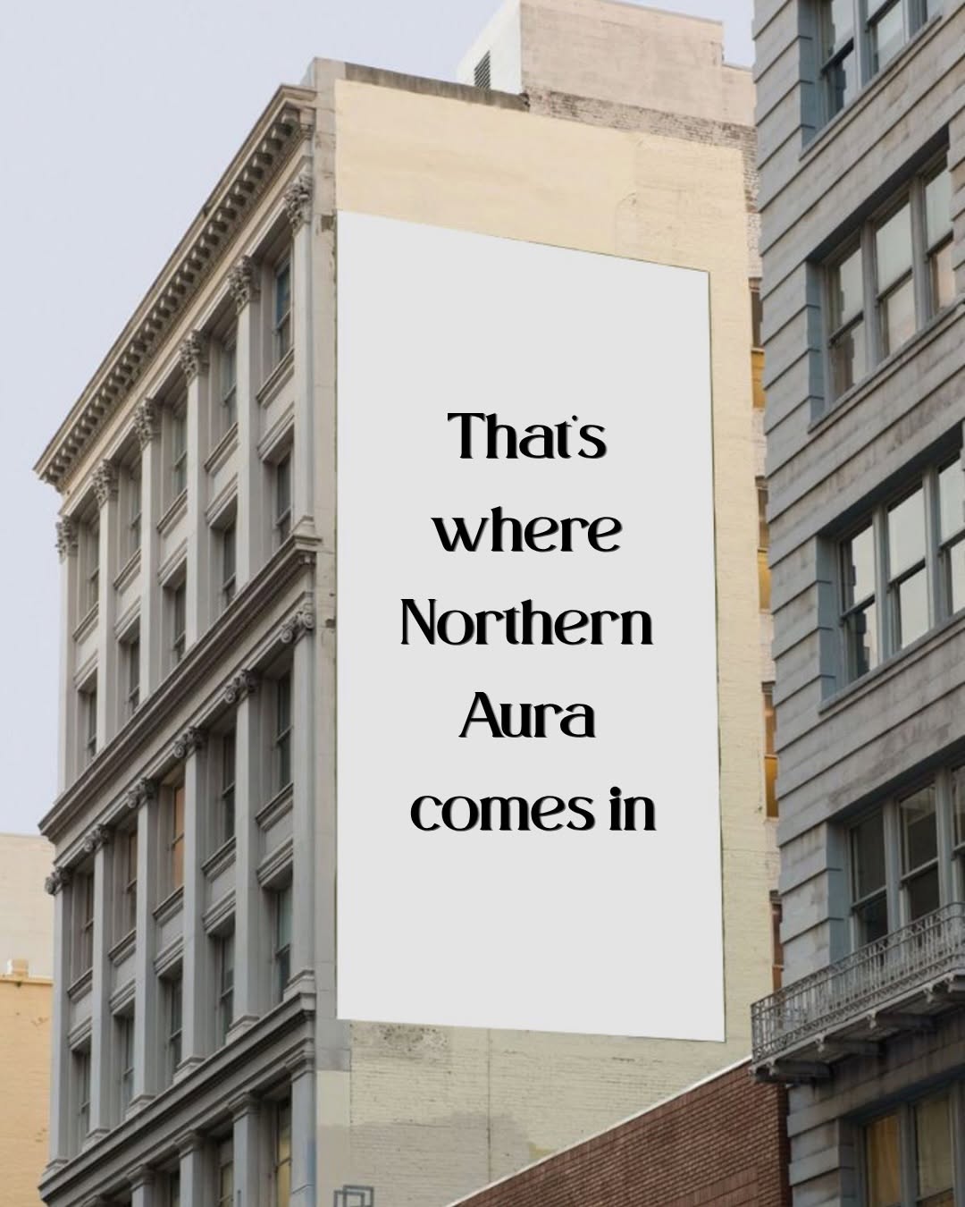 A large blank billboard on the side of a building with the text 'That's where Northern Aura comes in' displayed prominently.