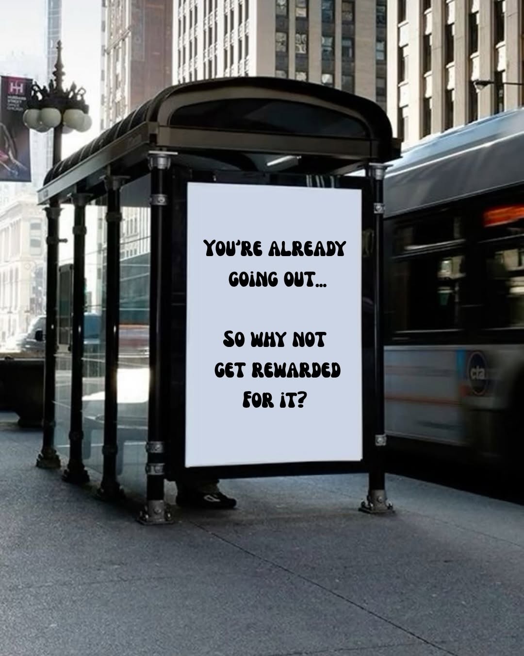 A bus stop in an urban setting featuring a promotional sign that encourages people to get rewarded for going out.